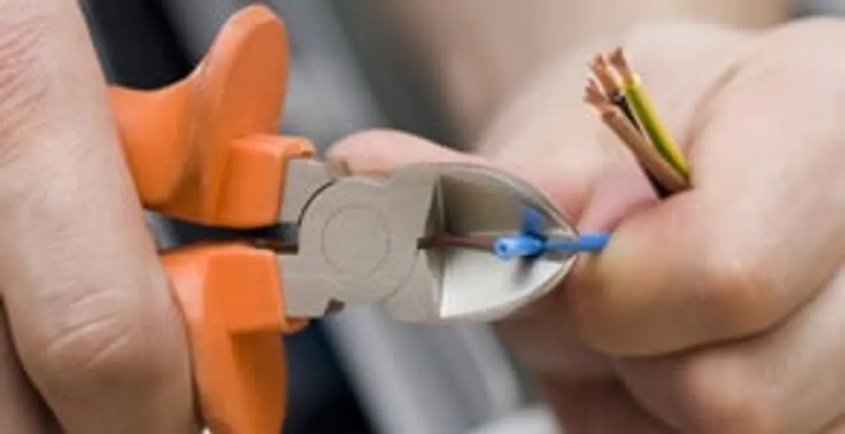 licensed electrician performing precise wire cutting and preparation during electrical service in Wilmington, NC